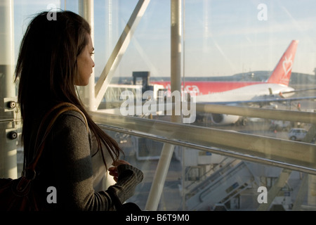 kontemplative junge Frau aus europäischen Flughafen Fenster Stockfoto