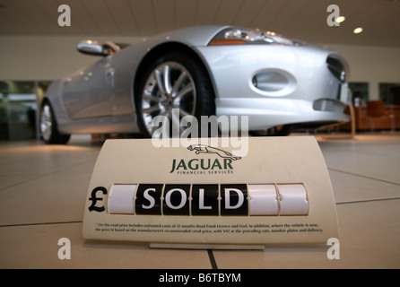 Verkauft-Zeichen vor einem Jaguar XK Stockfoto