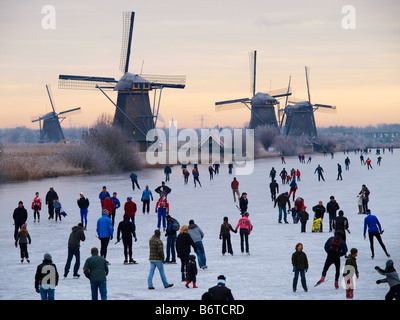 Winter in den Niederlanden viele Menschen Eislaufen auf Natureis Windmühlen von Kinderdijk Niederlande Stockfoto