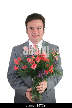 Einen schönen Mann in einem Anzug mit einem Rosenstrauß rosa Schatz über ein rosa packground Stockfoto