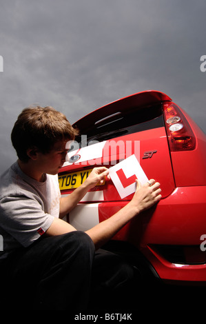 junger Mann legt l Platten auf roten Ford Fiesta st Stockfoto