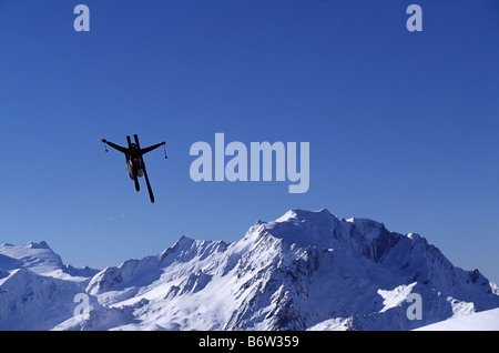 Skifahrer, die einen Sprung in der Luft mit Bergkulisse Wunderland Neuseeland Stockfoto