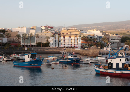 Blick über den Hafen und die Fischerboote von playa San juan in der Abenddämmerung zu den Restaurants am Strand Teneriffa Kanarische Inseln Spanien Stockfoto