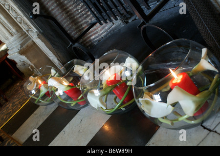 Goldfischglas Vasen mit Kerzen im Inneren in alten Kamin Stockfoto