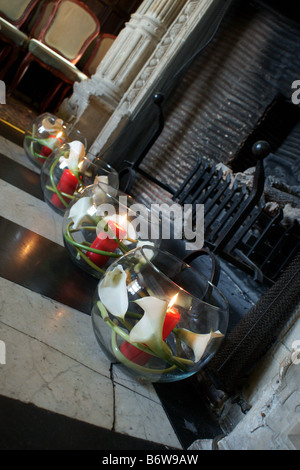 Goldfischglas Vasen mit Kerzen im Inneren in alten Kamin Stockfoto