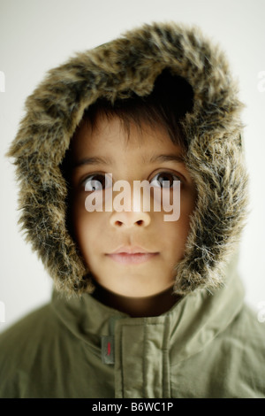 Kind trägt Parka Mantel mit Kapuze, die jungen im Alter von sechs Jahren mit Reißverschluss Stockfoto