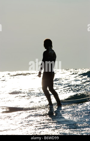 Surfer, die auf einem Brett am Ende einer Fahrt im Lake Michigan stehend Stockfoto