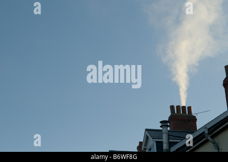 Rauch aus einem Kohle Feuer wogenden aus heimischen Kamin auf ein Reihenhaus-UK - kalten Wintermorgen Stockfoto