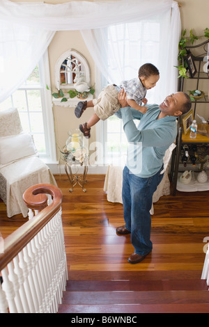 Ein Großvater seinem Enkel in die Luft heben Stockfoto