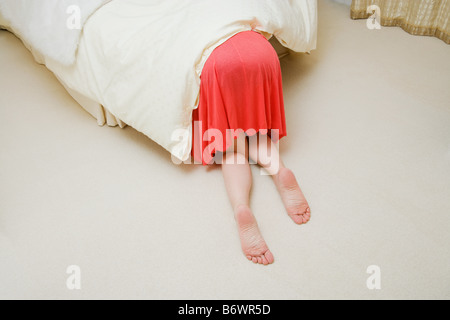 Frau unter Bett Stockfoto