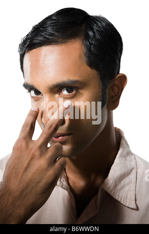 Junger Mann zeigte auf seine Augen Stockfoto