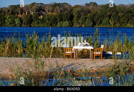 Sambia, Livingstone. Der River Club - Flitterwochen Mittagessen einrichten auf Insel in den Sambesi-Fluss vor der Lodge. Stockfoto