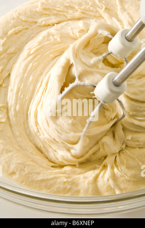 Schlagen von Eiern, Butter, Zucker und Mehl zusammen, um den Teig für Biskuit. Der Teig wurde dann verwendet, um Cupcakes machen. Stockfoto