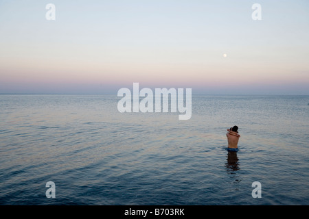 Junges Paar stehend im Wasser, umarmen einander, Gennadi Beach, Rhodos, Griechenland Stockfoto