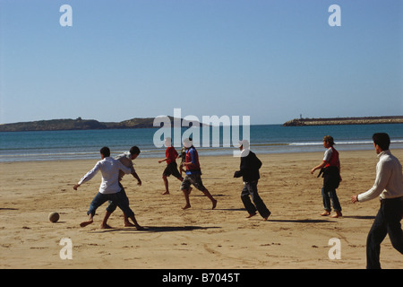 Junge Männer spielen Fußball am Strand, Küstenort Essaouira, Marokko, Afrika Stockfoto