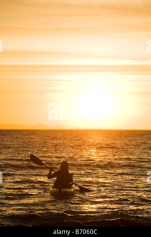 Eine Frau Seekajak in den Sonnenuntergang in Kino Bay, Mexiko. Stockfoto