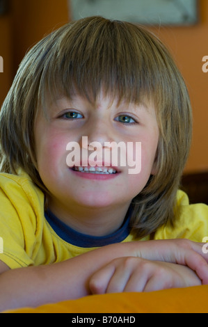 Lächelnd helle Augen 5 jährigen Jungen mit langen Haaren Stockfoto