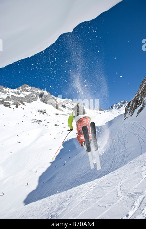 Ein junger Mann springt von einem Gesims beim Skifahren abseits der Pisten in der Nähe von St. Anton am Arlberg, Österreich. Stockfoto