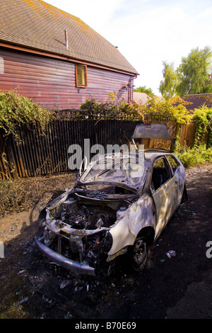 Auto in Gasse in der Nähe von Wohnhäusern ausgebrannt Stockfoto