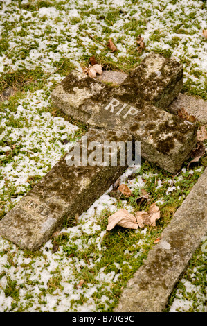 Eine kreuzförmige Grabstein mit den Initialen "RIP", liegend auf dem Boden gebrochen. Stockfoto