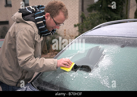 Student Schaben Windschutzscheibe frei von Frost an einem frostigen Wintermorgen. Stockfoto