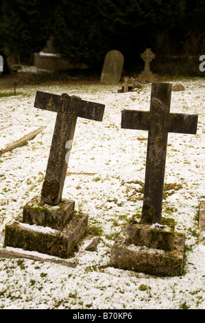 Ein paar Kreuze auf einem verschneiten Friedhof in Surrey. Stockfoto
