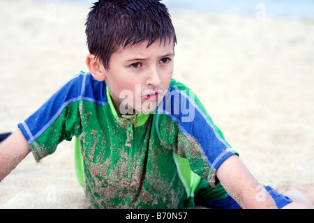 Ein kleiner Junge posiert in den Sand am Strand an einem warmen Sommertag. Stockfoto