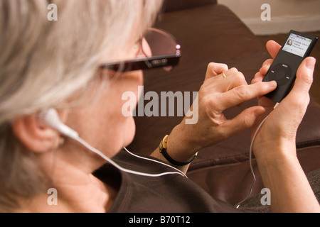 Eine Frau auf einem tragbaren MP3-Player (Ipod) Stockfoto