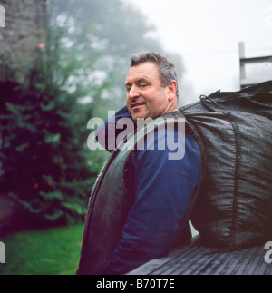 Porträt des Kohlemanns Robert Brown von Sennybridge, der Kohle liefert Sack für Festbrennstoffofen in Llanwrda Carmarthenshire Wales UK BritainKATHY DEWITT Stockfoto