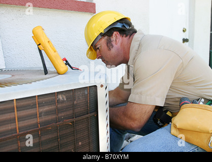 Eine Klimaanlage Mechaniker arbeitet an einem Kompressor-Einheit Stockfoto