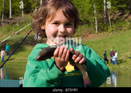 Junge Mädchen lächelt halten die Forelle gefangen sie nur im Teich Stockfoto