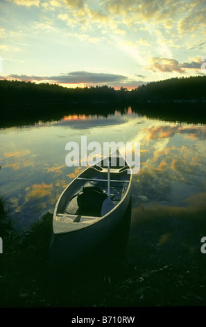 USA MINNESOTA A Kanu sitzt auf dem Ufer von Elch-See bei Sonnenuntergang in Boundary Waters Kanugebiet im Norden von Minnesota Stockfoto