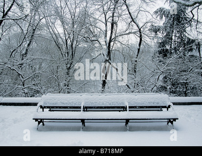 New York City Central Park leerer Park, isolierte Bank, die im Winter im Schnee vergraben wurde. Einsame schneebedeckte Bank, auf der niemand sitzt. New York Stockfoto