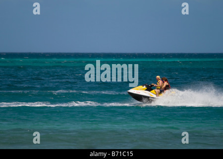 2 Personen fahren ein Jetboot Sea Doo Jet-Ski in Aruba Stockfoto