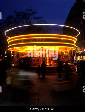 Kirmes ride oder Karussell in Leicester Square London während der Feiertage Weihnachten mit Menschen zu Fuß, stoppen zu suchen Stockfoto