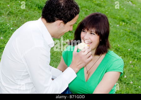 Junges Paar in einem Park einen Apfel essen Stockfoto