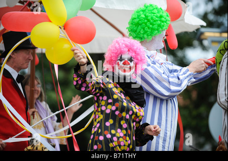 Eine Frau als ein Clown-Wellen von der Prozession als sie Teil in Worthing Karneval nimmt verkleidet. Bild von Jim Holden. Stockfoto