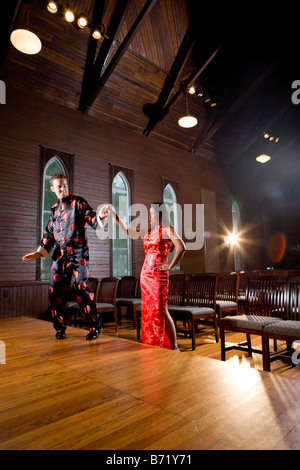 Junges Paar tragen traditionelle asiatische Kleidung zu Fuß bis zu Altar in der Kirche Stockfoto
