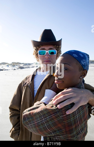 Interracial Pärchen stehen am Strand mit Arm um Stockfoto
