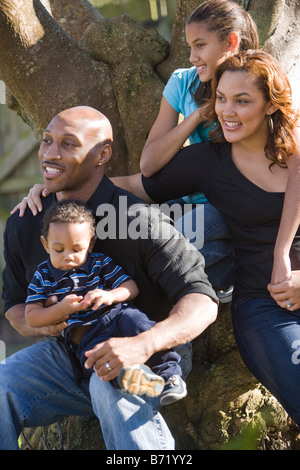 Glückliche afroamerikanische Familie von Baum im Hinterhof sitzen Stockfoto