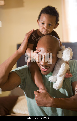 Glückliche afroamerikanischen Vater spielen mit Baby Sohn auf Schultern Stockfoto