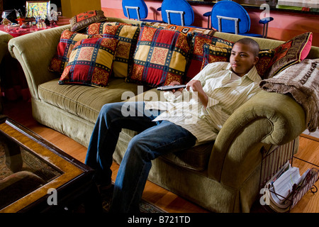 African American Teenager sitzen auf der Couch vor dem Fernseher Stockfoto