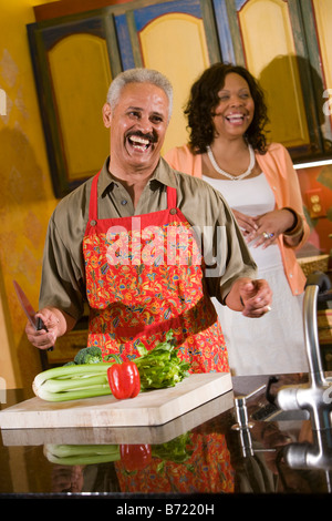 Glücklich afroamerikanischen Paar mittleren Alters Lachen in der Küche zu Hause Stockfoto