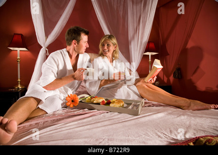 Paar beim Frühstück im Bett mit Baldachin Stockfoto