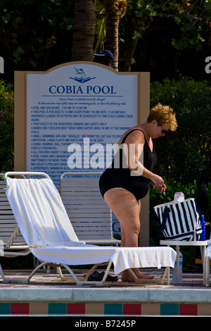 Palm Beach Shores, Schwimmbad, ältere große beleibte Dame in Sonnenbrillen & schwarzen Badeanzug USA Stockfoto