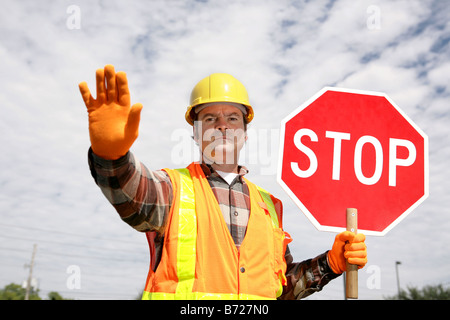 Ein Bauarbeiter Verkehr mit einem Stop-Schild anhalten Stockfoto