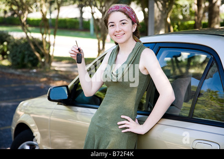 Recht jugendlich Mädchen stützte sich auf ihr neues Auto und Autoschlüssel halten Stockfoto