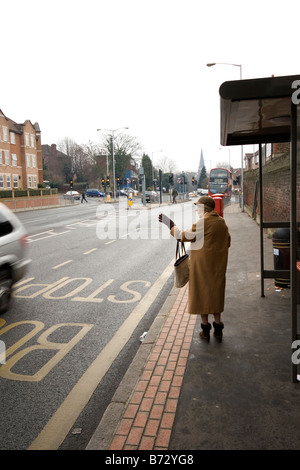 Eine Rentnerin wartet auf einen Bus. Stockfoto