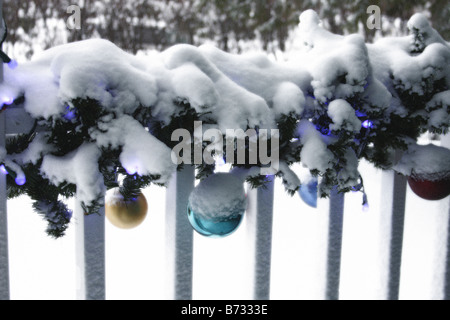 Eine Veranda mit Weihnachtsbeleuchtung Dekorationen und Ornamente mit Schnee bedeckt Stockfoto
