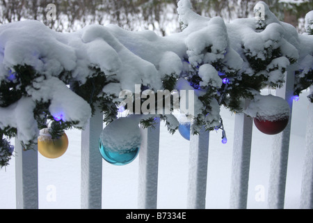 Eine Veranda mit Weihnachtsbeleuchtung Dekorationen und Ornamente mit Schnee bedeckt Stockfoto
